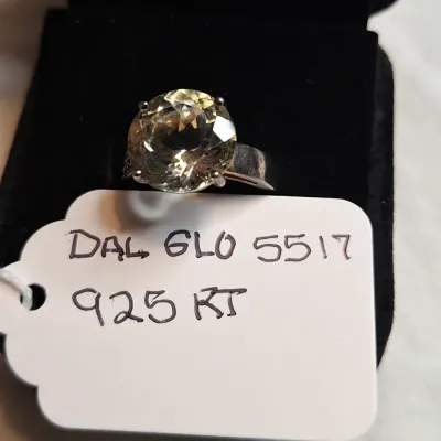 Sterling silver ring featuring a large, round-cut pale yellow gemstone, possibly lemon quartz, secured in a four-prong setting.