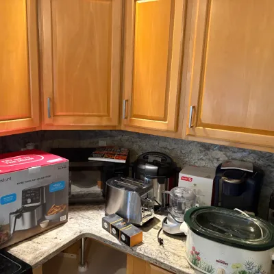 Assorted kitchen appliances including an Instant Pot air fryer in its original box, a stainless steel toaster, a Rival crockpot with...