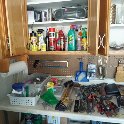 Sale Photo Thumbnail #13: Assorted workshop tools, cleaning supplies, and a Sony boombox arranged on a workbench and inside wooden cabinets.