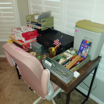 Sale Photo Thumbnail #14: Modern wooden writing desk with a black metal frame, paired with a pink upholstered swivel office chair and various office supplies.