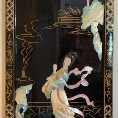 Sale Photo Thumbnail #66: Vintage Chinese black lacquer wall plaque featuring an oval shape with mother-of-pearl inlay depicting a female figure, mountains, and floral motifs.