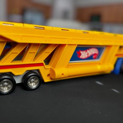 Sale Photo Thumbnail #33: Vintage Hot Wheels yellow plastic car hauler truck with blue and red accents, showing some light wear.