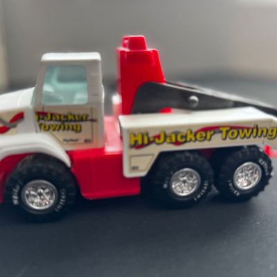 Sale Photo Thumbnail #37: Vintage Nylint "Hi-Jacker Towing" toy tow truck, featuring a red and white plastic body with original decals and chrome-finished wheels.