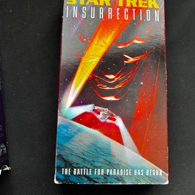 Sale Photo Thumbnail #24: Star Trek Insurrection VHS tape in its original cardboard sleeve, showing some light wear along the edges.