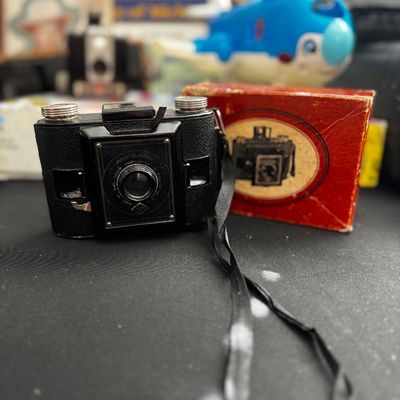 Sale Photo Thumbnail #65: Vintage Ansco Clipper folding camera with its original red cardboard box, circa 1940s.