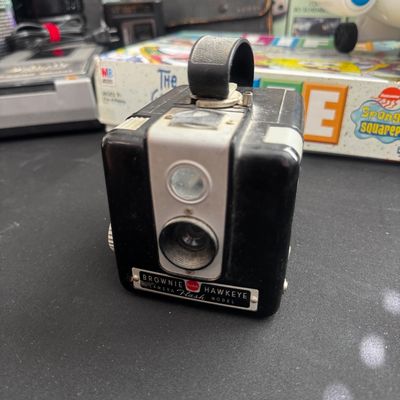 Sale Photo Thumbnail #63: Vintage Kodak Brownie Hawkeye Flash Model box camera, featuring a black Bakelite body and top carrying strap, circa 1950s.