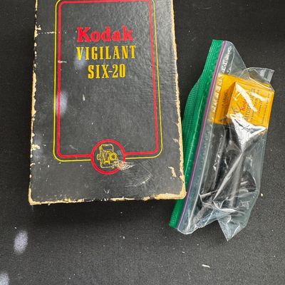 Sale Photo Thumbnail #68: Vintage Kodak Vigilant Six-20 camera box showing some edge wear, accompanied by a bagged Kodak Daylight Filter Series IV.