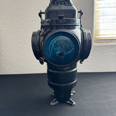Sale Photo Thumbnail #14: Vintage cast metal railroad switch lantern with a cracked blue glass lens, painted in a black finish.