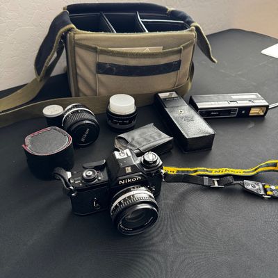 Sale Photo Thumbnail #3: Vintage Nikon EM 35mm SLR film camera with a Nikon lens, strap, additional lenses, flash, and a canvas camera bag.