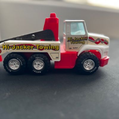 Sale Photo Thumbnail #35: Vintage Nylint "Hi-Jacker Towing" toy tow truck in red and white plastic and pressed steel, showing some light wear.