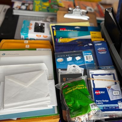 Assorted office and crafting supplies, including Avery name badge labels, CD pages, a bag of Staples rubber bands, envelopes, and a...