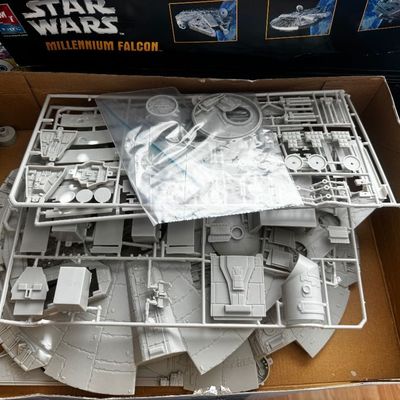 Vintage AMT Ertl Star Wars Millennium Falcon plastic model kit, unbuilt in box with grey plastic sprues and parts.