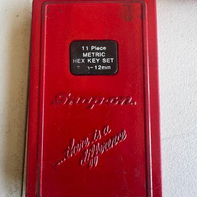 Sale Photo Thumbnail #74: Vintage Snap-on red metal case for an 11-piece metric hex key set, featuring embossed branding and slogan.