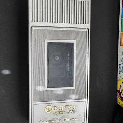 Sale Photo Thumbnail #61: Vintage Kinyo Super Slim VHS tape rewinder, model UV-413, in a silver plastic housing showing some wear.