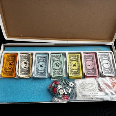 Sale Photo Thumbnail #29: Vintage Michigan-themed board game components, including play money, property cards, and game pieces in a white organizer tray.