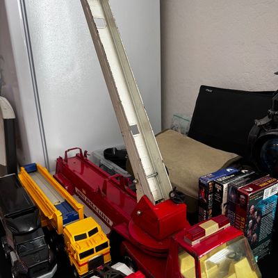 Sale Photo Thumbnail #43: Vintage Tonka Aerial Hook-N-Ladder fire truck toy with extending white ladder, shown alongside other vintage toy trucks and VHS tapes.