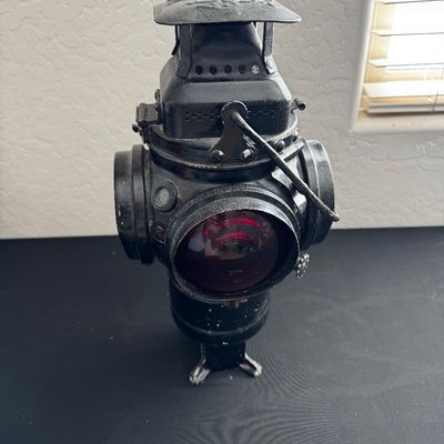 Sale Photo Thumbnail #16: Vintage Adlake non-sweating railroad switch lantern, featuring a black metal body with a red glass lens.