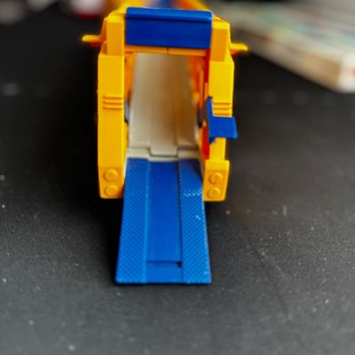 Sale Photo Thumbnail #32: Vintage plastic toy car carrier trailer in yellow and blue, featuring a fold-down ramp.