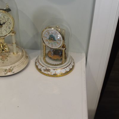 Sale Photo Thumbnail #24: Vintage Wizard of Oz anniversary-style clock under a glass dome, featuring a decorative porcelain base and character illustrations on the dial.