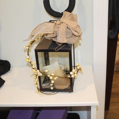 Sale Photo Thumbnail #29: Decorative black metal lantern containing a pillar candle and fairy lights, adorned with a burlap bow and a faux berry garland.