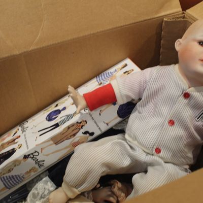 Sale Photo Thumbnail #33: Vintage porcelain baby doll dressed in a pinstripe baseball uniform, sitting in a cardboard box next to a Barbie doll box.