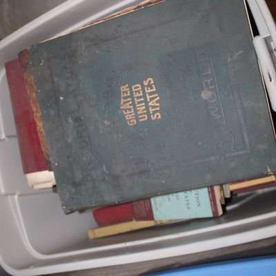 Sale Photo Thumbnail #12: Vintage "Greater United States and World" atlas with a worn green cover and gold lettering, stored in a plastic bin with other antique books.