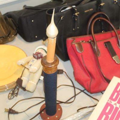 Assorted household items including a red canvas tote bag, a black Michael Kors handbag, a stack of yellow plates, and a decorative...