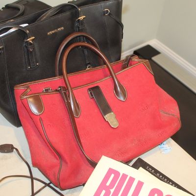 Dooney & Bourke red canvas tote bag with brown leather trim, shown alongside a black Michael Kors leather tote bag.