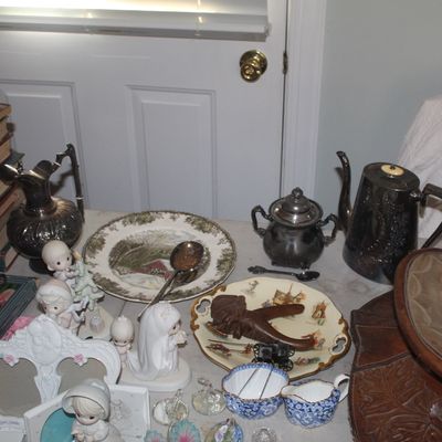 Assortment of vintage collectibles including Precious Moments figurines, silver-plated teaware, decorative plates, old books, and a...