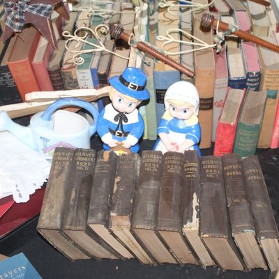 Collection of vintage books, including a multi-volume set of Milman's Gibbon's Rome, displayed alongside small pilgrim...