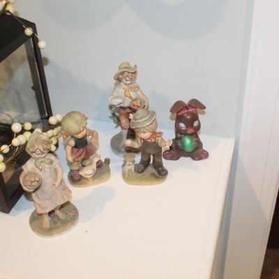 Sale Photo Thumbnail #34: Collection of vintage porcelain and ceramic figurines, including Hummel-style children and a small Easter bunny holding an egg.