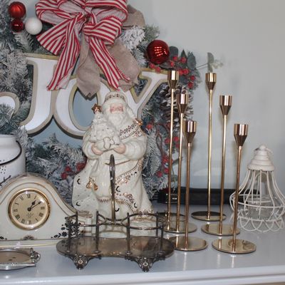 Assorted Christmas decorations, including a ceramic Santa figurine, a white mantel clock, a decorative wreath, and a set of modern...
