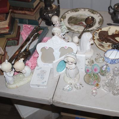 Assortment of vintage collectibles including Precious Moments figurines, decorative picture frames, cut glass salt cellars, and stacks of...