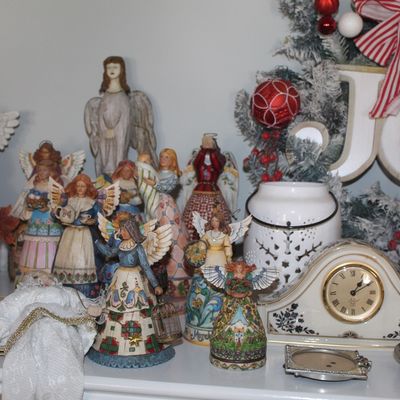 Collection of Jim Shore Heartwood Creek angel figurines, a white ceramic mantel clock, and various Christmas decorations.