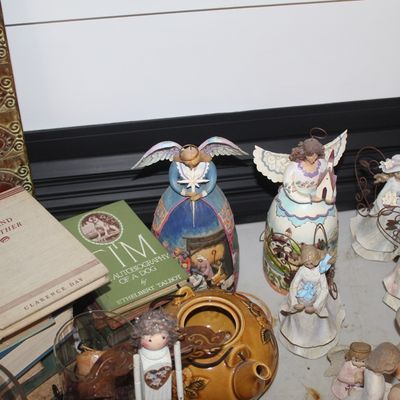 Collection of Jim Shore Heartwood Creek angel figurines displayed alongside vintage books, including "God and My Father" by...