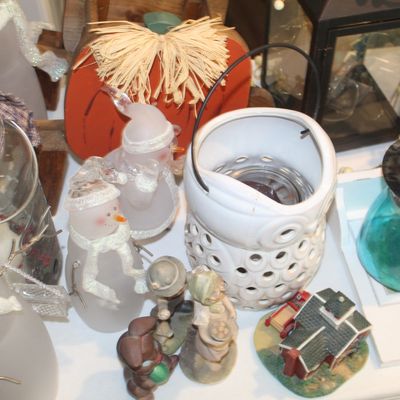 Assortment of seasonal home decor, including frosted glass snowman figurines, a wooden pumpkin, a white ceramic owl lantern, and various...