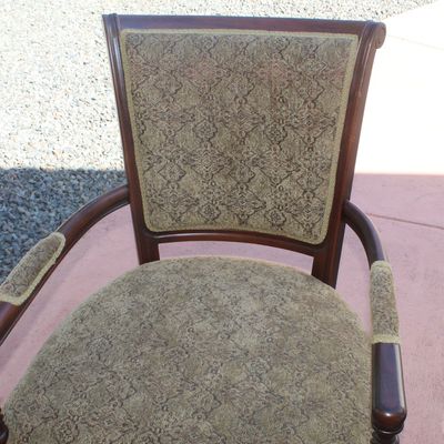 Sale Photo Thumbnail #38: Traditional wooden armchair featuring patterned olive green upholstery on the seat, backrest, and arm pads, accented by spiral-turned front legs.