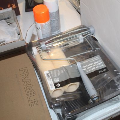 An 8-piece paint tray kit in original plastic packaging, shown alongside spray paint cans and other boxed items.