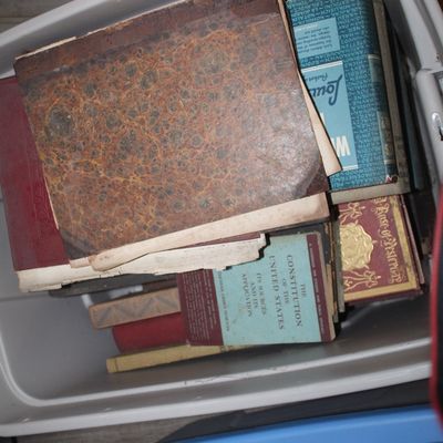 Sale Photo Thumbnail #13: A collection of vintage and antique books, including a marbled-cover volume and a copy of "The Constitution of the United States," stored inside a plastic bin.