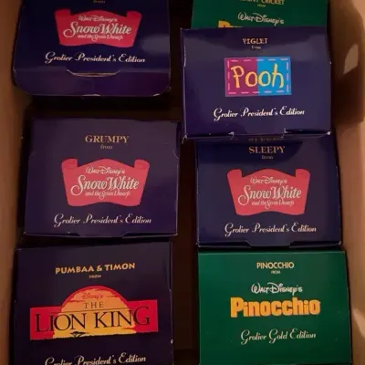8 Disney Grolier President's Gold Edition Christmas ornaments in boxes.