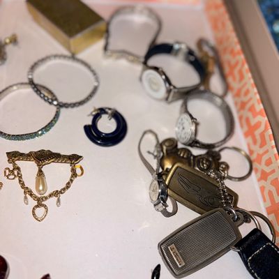Collection of vintage jewelry and accessories, including wristwatches, bangles, keychains, and gold-tone brooches.