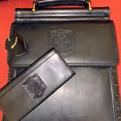 Black Belle Rose leather document bag and matching long wallet set, featuring embossed crest detailing and faux-croc trim.