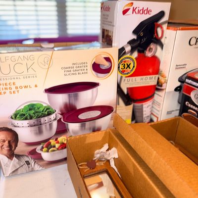 Assorted household items, including a boxed Wolfgang Puck mixing bowl and prep set, a Kidde fire extinguisher in its original packaging,...