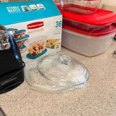 Collection of kitchen items including a black Hamilton Beach electric can opener, Pyrex glass baking dishes with red lids, a clear glass...