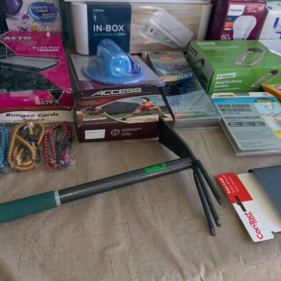 Assortment of boxed household items, hardware goods, air fresheners, and a small garden hand tiller.