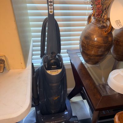Kenmore Progressive Direct Drive upright vacuum cleaner in dark gray finish with attached hose and tools.