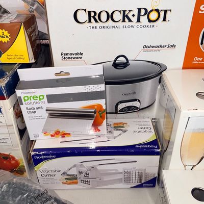 Collection of boxed kitchen appliances and gadgets, including a Crock-Pot slow cooker, Progressive Vegetable Cutter, and Progressive Bash...