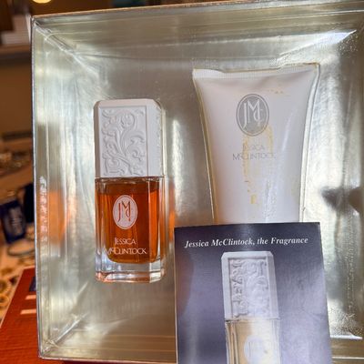 Vintage Jessica McClintock fragrance set featuring a bottle of perfume and a tube of scented lotion in a gold metallic presentation box...