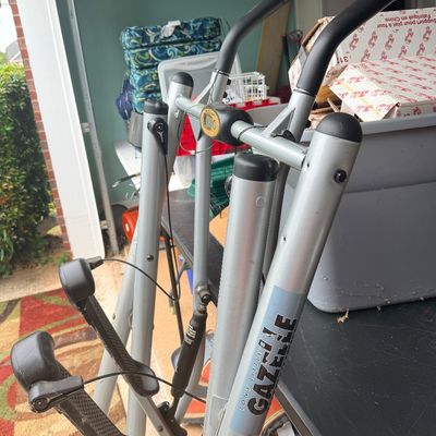 Tony Little Gazelle folding glider exercise machine featuring a silver metal frame, padded handlebars, and foot platforms.