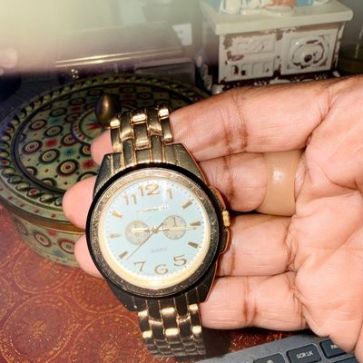 Gold-tone quartz wristwatch featuring a white dial with gold numerical indices and decorative sub-dials, fitted with a link bracelet.